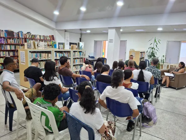 Carlos Sánchez Ortiz conversando con una audiencia en una biblioteca.